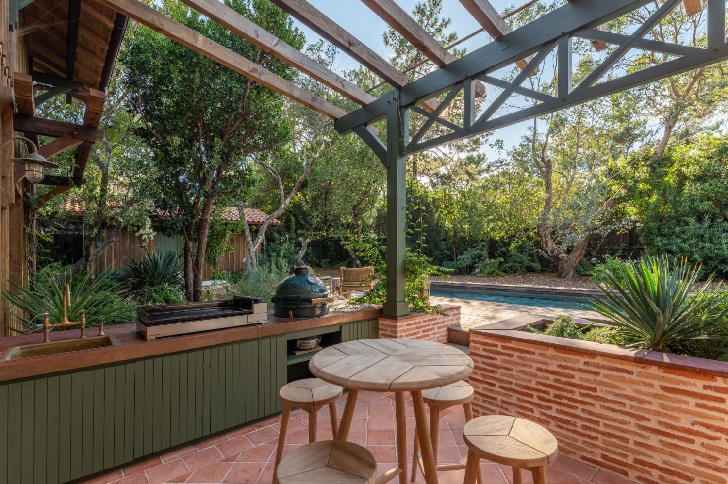 Cuisine d’été et piscine d’une villa entretenue par l’agence, au Cap Ferret